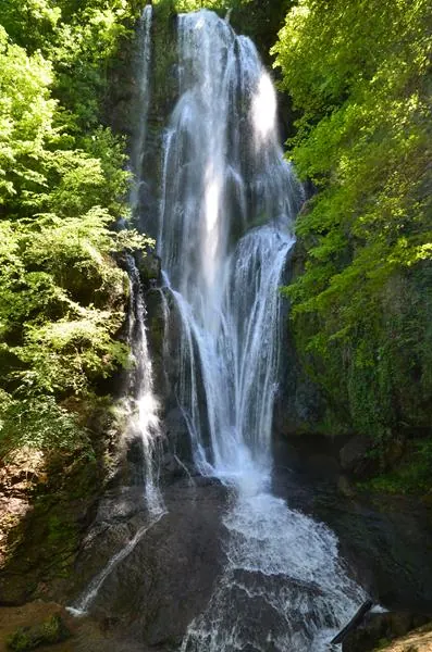De Cascade d'Autoire, een waterval van 30 meter hoog die uit de rotswand van het cirque stroomt, omgeven door bos