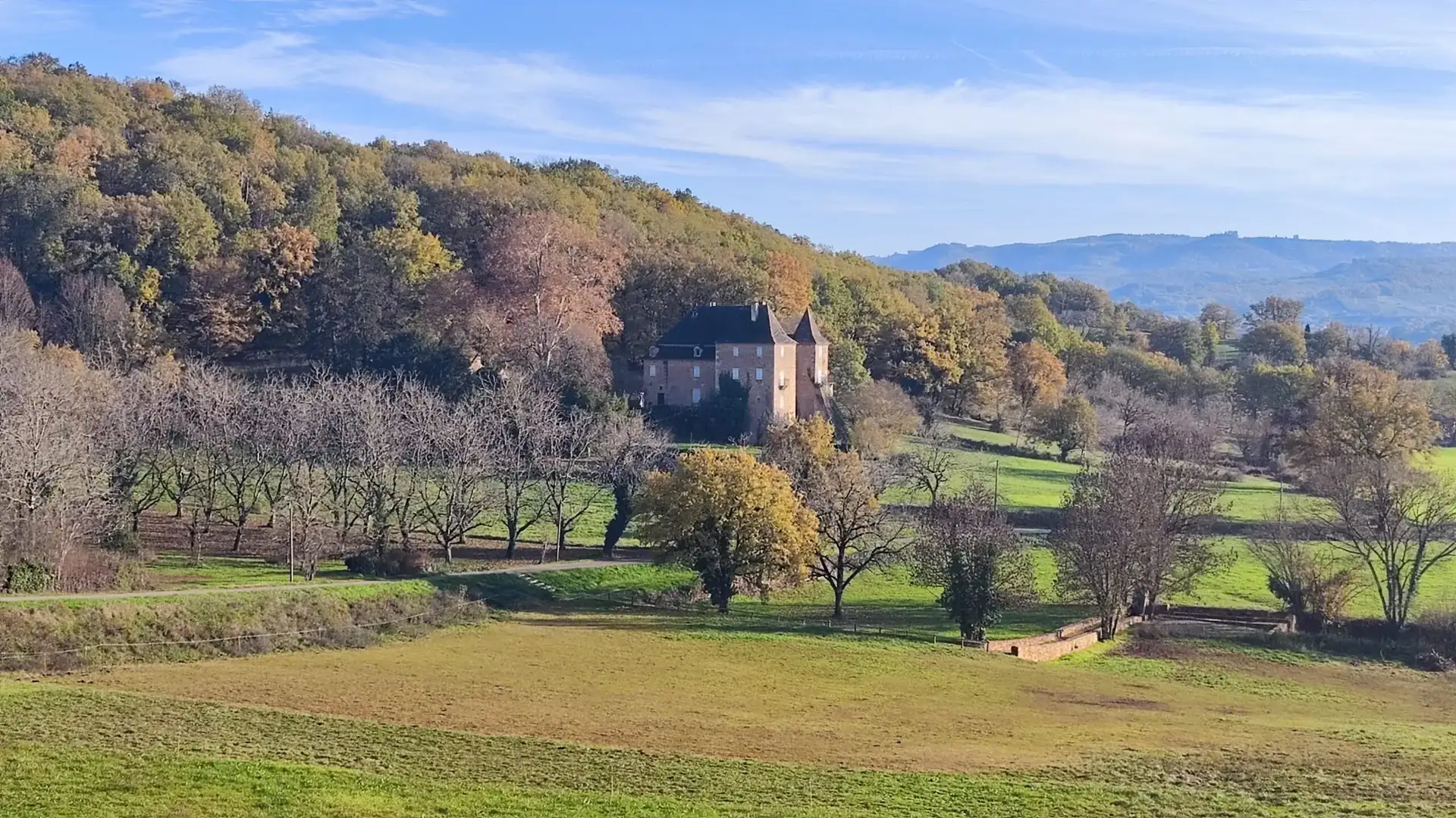 Het château in de vallei, omgeven door bos en weiland