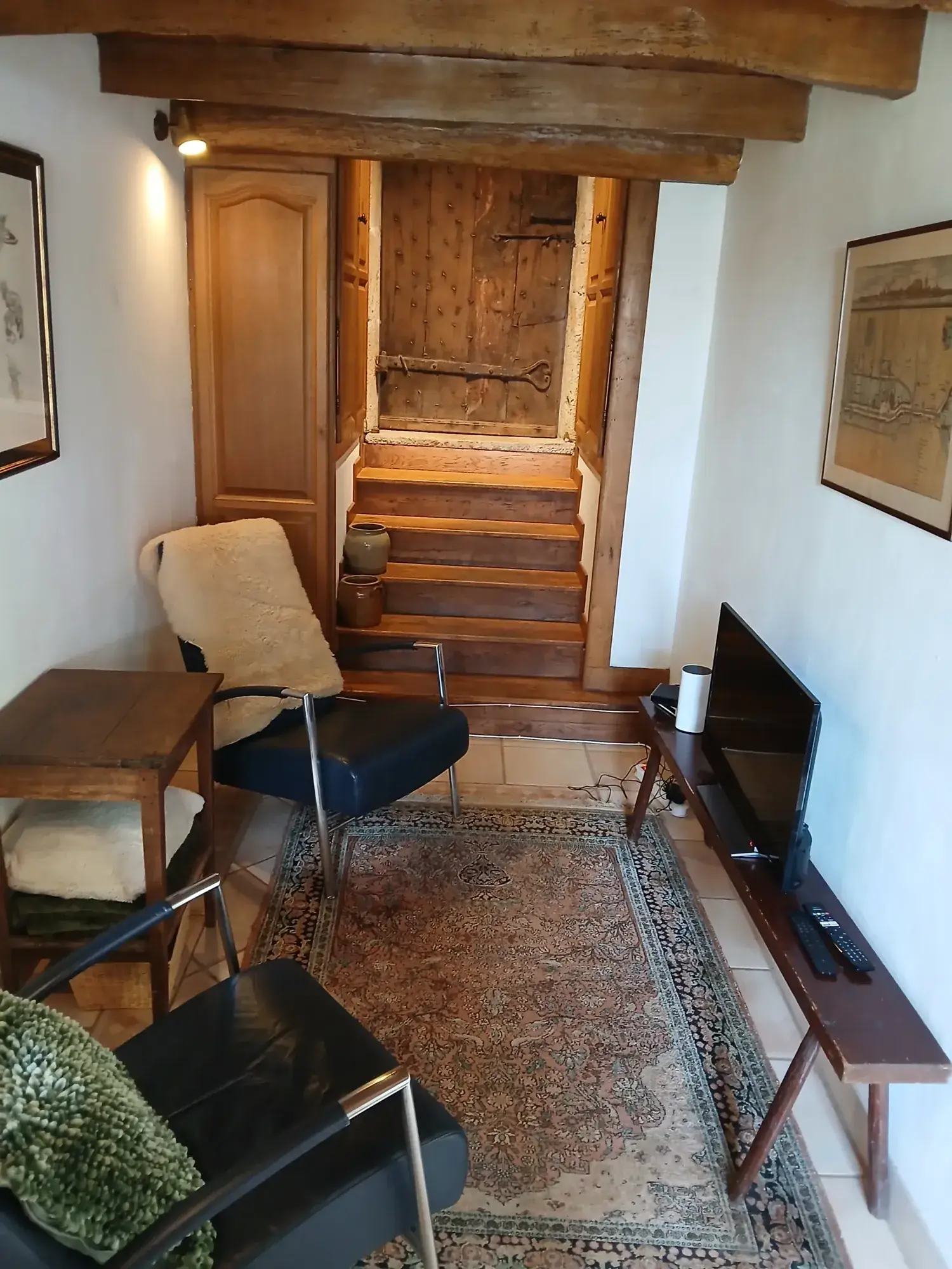 Coin salon près de l'escalier en bois du gîte Louis IX