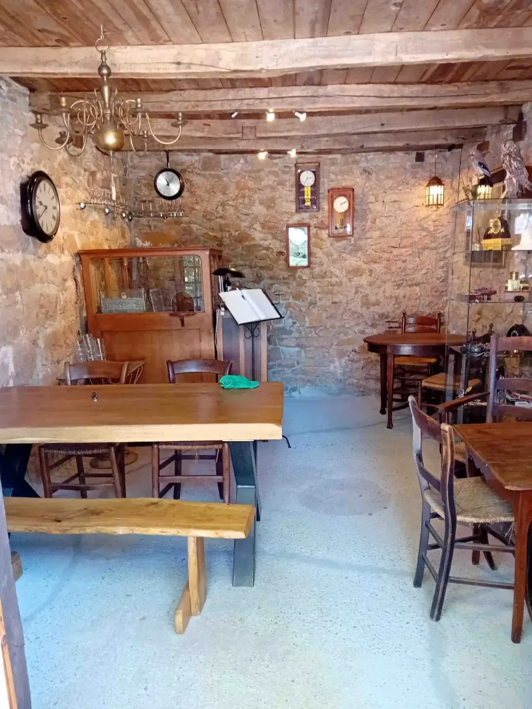 Der Salon de thé mit langen Tischen und einer Bank in einem Raum mit Holzbalken