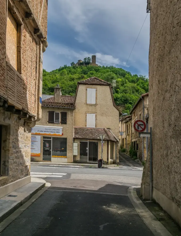 The ruins of the castle of Saint-Laurent-les-Tours on the hill above Saint-Céré, seen from a street in the town
